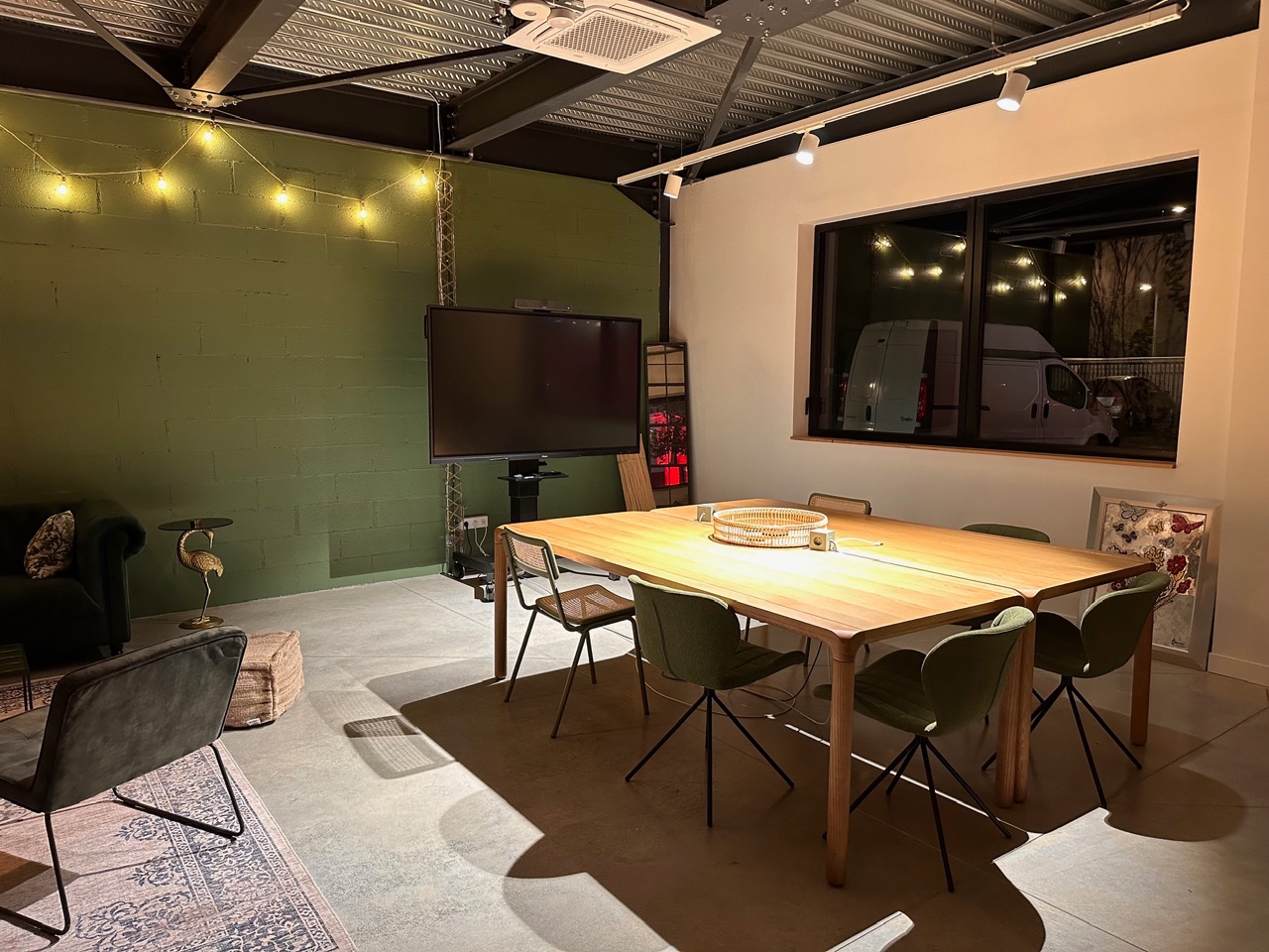 ITQ Security à Serris — Salle de réunion aménagée avec carrelage, table en bois et mur peint en vert