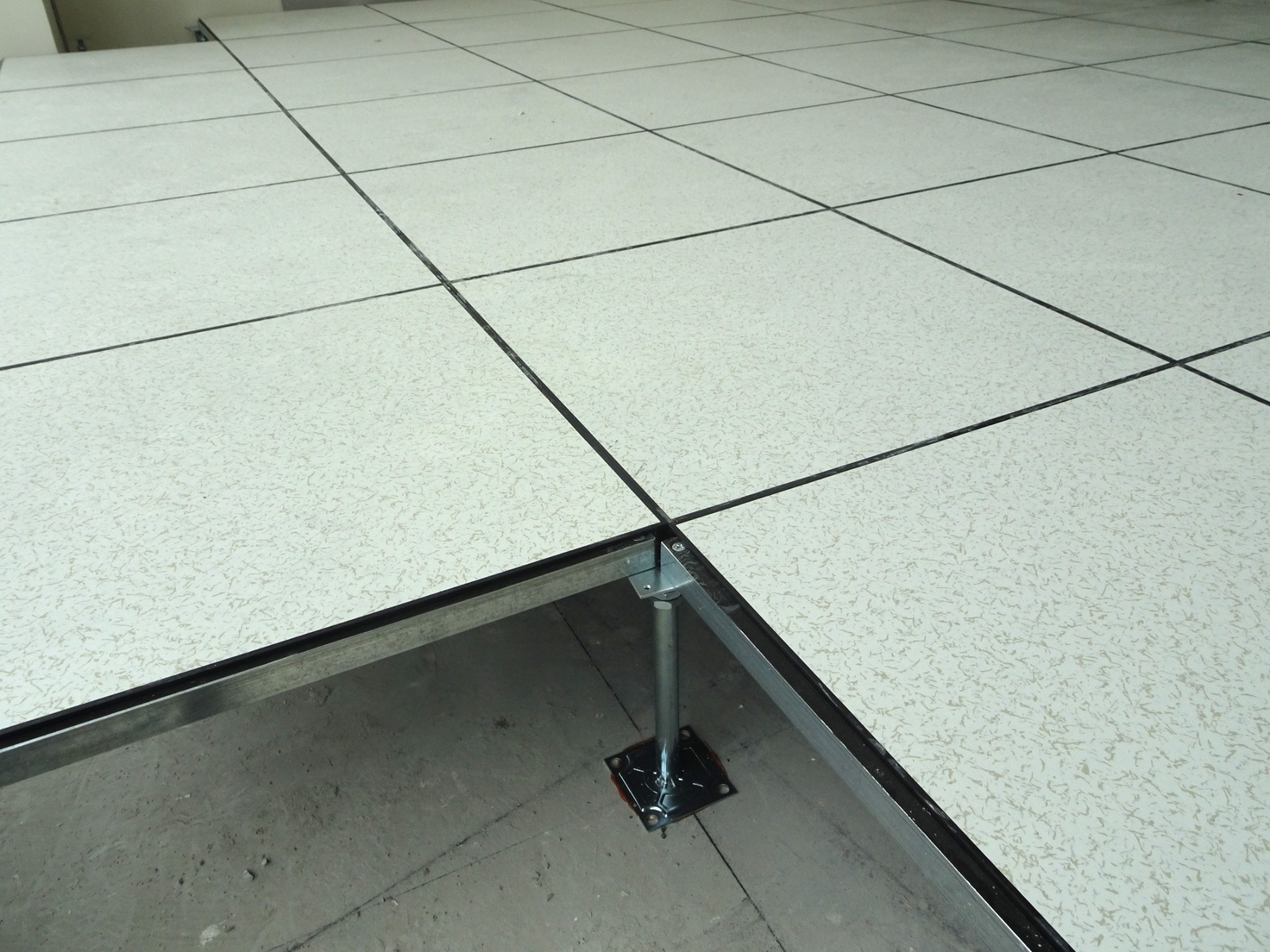 Dalles de plancher technique surélevé avec une ouverture montrant la structure sur vérins