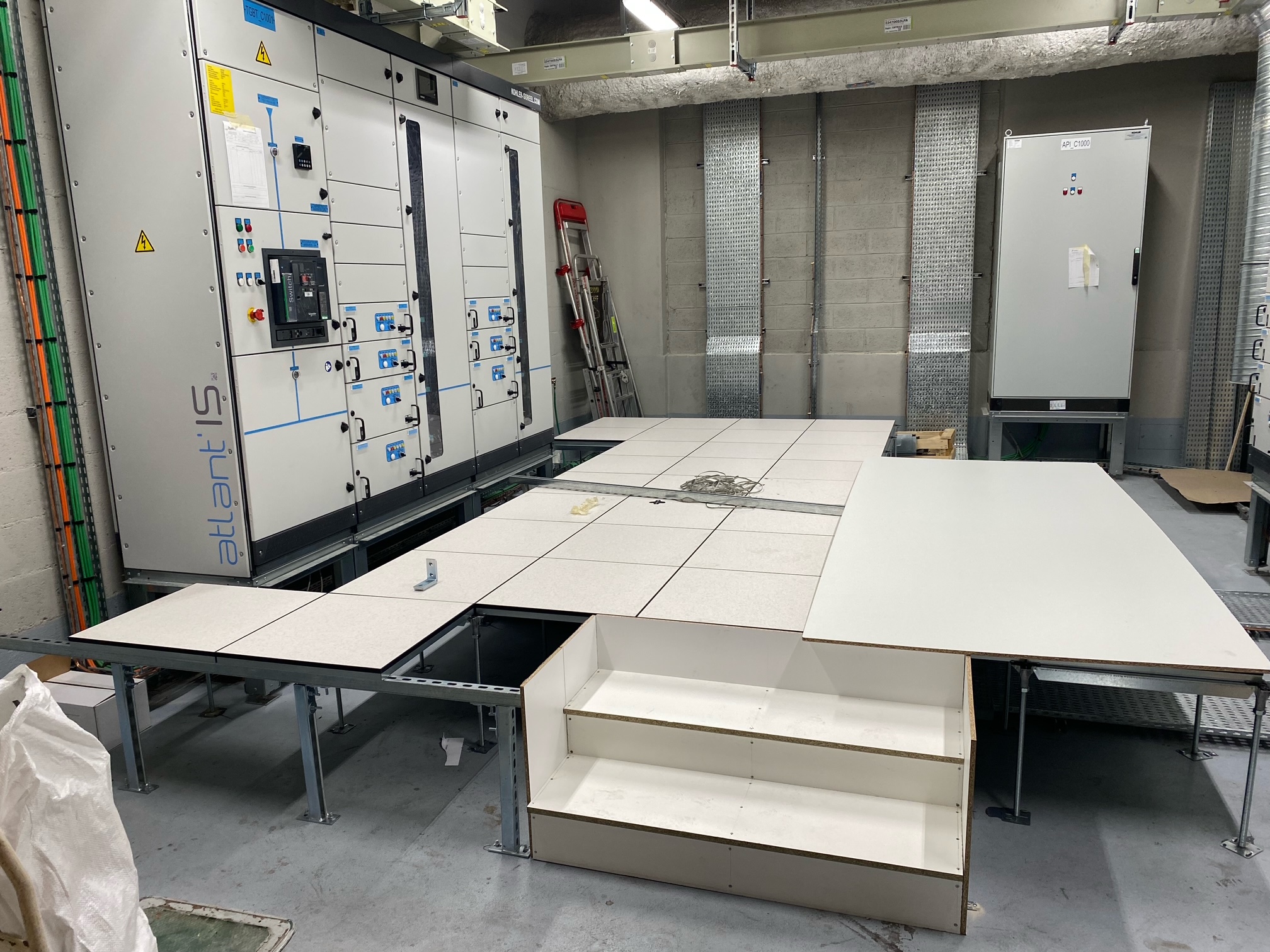 Structure du plancher technique en cours de pose devant les armoires électriques